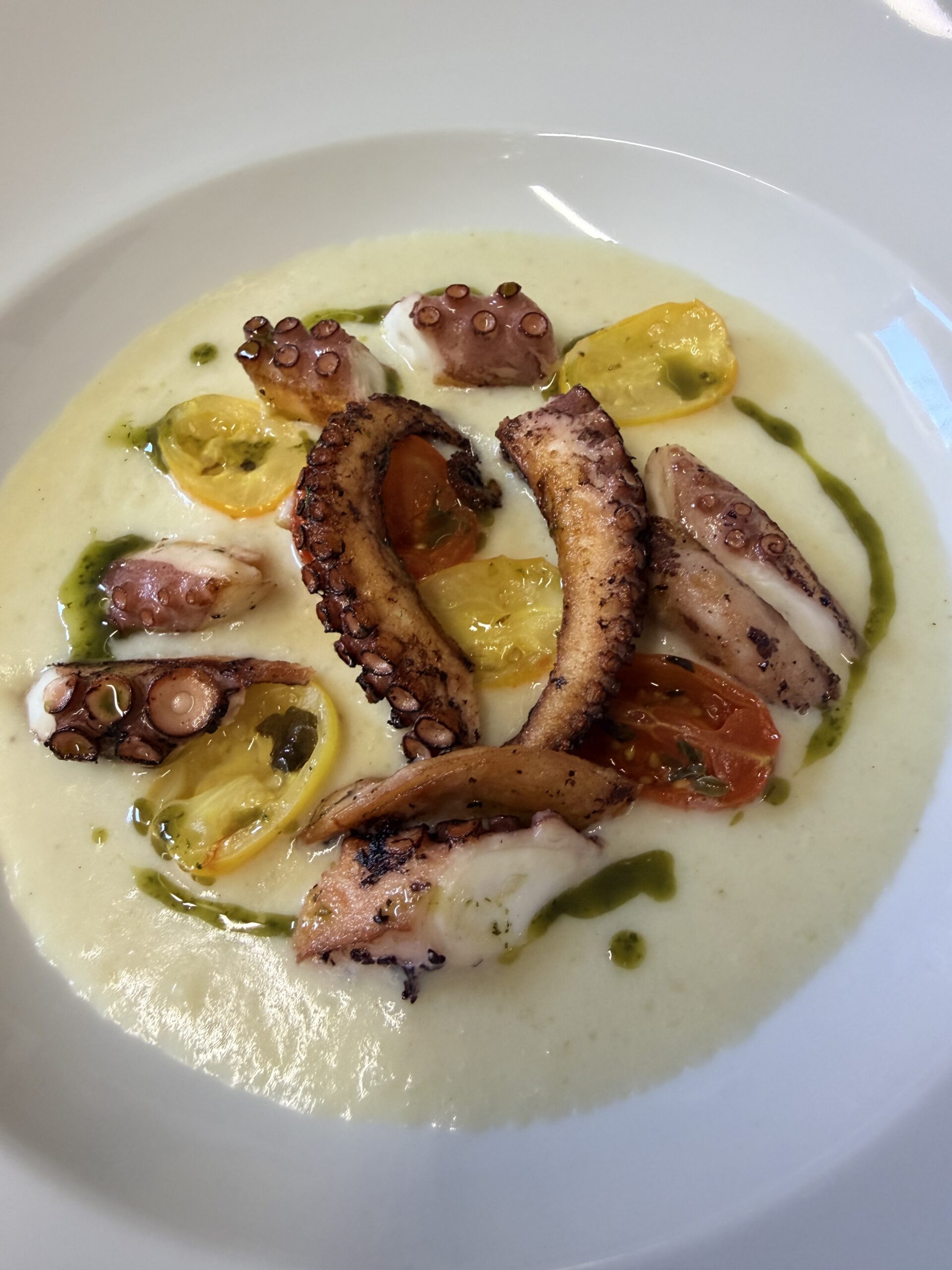 Polpo arrosto su cremoso di patate ,gocce di basilico e couline di pomodorini conffit
